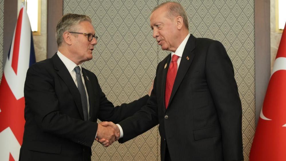 Turkish President Gives UK Prime Minister a Live Revolver at NATO Summit